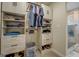 Organized walk-in closet with shelving, drawers, and hanging rods next to full bathroom at 480 Mitchell Rd, Covington, GA 30014
