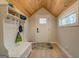 Mud room entryway featuring a white bench, hooks for coats, light wood flooring, and a wood plank ceiling at 480 Mitchell Rd, Covington, GA 30014