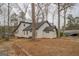 Back exterior showcasing a white exterior, mature trees, and an air conditioning unit at 480 Mitchell Rd, Covington, GA 30014