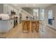 Modern kitchen with stainless steel appliances, bar-stool seating, light wood flooring, and staircase at 480 Mitchell Rd, Covington, GA 30014