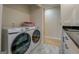 Laundry room featuring modern washer and dryer next to bathroom with marble tile at 480 Mitchell Rd, Covington, GA 30014