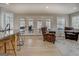 Open-concept living room with comfortable seating, bar-stool seating, light wood flooring, and a glass door to the exterior at 480 Mitchell Rd, Covington, GA 30014