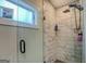 Luxurious glass shower with marble-style tile, rain shower head, and a frosted window at 480 Mitchell Rd, Covington, GA 30014