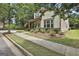 Beautiful home exterior surrounded by lush greenery, showcasing meticulous landscaping and a welcoming sidewalk at 135 Adam Ridge Ln, Fayetteville, GA 30214