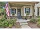 Inviting front porch with American flag, blue door with wreath, and charming shuttered windows with flower boxes at 135 Adam Ridge Ln, Fayetteville, GA 30214
