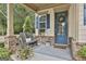 Cozy front porch with seating, potted plants, and a decorative wreath on the inviting blue front door at 135 Adam Ridge Ln, Fayetteville, GA 30214