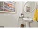 Stylish half bath featuring a pedestal sink, decorative mirror, and tasteful accents, adding convenience for guests at 135 Adam Ridge Ln, Fayetteville, GA 30214