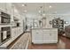 Open-concept kitchen featuring white cabinetry, stainless steel appliances, and central island at 135 Adam Ridge Ln, Fayetteville, GA 30214