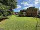 A large, grassy backyard showcases the exterior of the home under a blue sky at 4402 Auburn Hills Drive, Stone Mountain, GA 30083