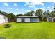 View of the backyard that features a well-maintained lawn, patio, and an additional storage unit at 80 David Rd, Hampton, GA 30228