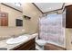Bathroom boasts a marble vanity, decorative shower curtain, and wood-look floors at 80 David Rd, Hampton, GA 30228