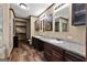 Bathroom featuring double sinks, wooden cabinetry, and wood-look tile flooring at 80 David Rd, Hampton, GA 30228