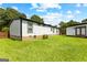 Exterior view of the home's backyard featuring a well-manicured lawn and an additional storage unit at 80 David Rd, Hampton, GA 30228