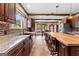 Spacious kitchen with dark wood cabinets, expansive island, and wood-look tile flooring at 80 David Rd, Hampton, GA 30228