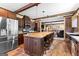 Kitchen with a large wood island, dark cabinets, and stainless appliances overlooking the living area at 80 David Rd, Hampton, GA 30228