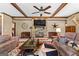 Inviting living room featuring a stone fireplace, beamed ceiling, and stylish furnishings at 80 David Rd, Hampton, GA 30228