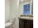 Powder room featuring a granite countertop, wood cabinet and tiled floors at 6765 Crofton Dr, Alpharetta, GA 30005