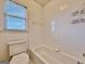 Bright tiled bathtub and toilet with window at 6765 Crofton Dr, Alpharetta, GA 30005