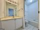 Bright bathroom featuring a single vanity sink, white cabinets, and a tub at 6765 Crofton Dr, Alpharetta, GA 30005