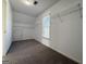 Neutral bedroom with window, carpet, closet, and wire shelving at 6765 Crofton Dr, Alpharetta, GA 30005