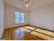 Bright bedroom featuring hardwood floors, a ceiling fan, and a large window at 6765 Crofton Dr, Alpharetta, GA 30005