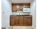 Kitchenette featuring wooden cabinets with granite countertops, microwave, and tile floors at 6765 Crofton Dr, Alpharetta, GA 30005