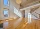 Sunlit living room with hardwood floors, a modern chandelier, and open staircase to the second floor at 6765 Crofton Dr, Alpharetta, GA 30005