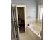 Relax in this bathroom featuring a soaking tub, tile flooring, and ample natural light at 75 Orchard Dr, Covington, GA 30014