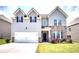 Two-story house with gray siding, stone accents, and a two-car garage at 5550 Rialto Way, Cumming, GA 30040