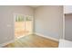 A bedroom with white trim, beige colored walls, hardwood floors, and sliding glass doors with views of the outdoors at 192 Pecan Dr, Canton, GA 30114