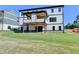 Expansive backyard view of the home's exterior featuring covered patios and lush greenery at 2255 Buford Dam Rd, Buford, GA 30518