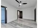 Spacious bedroom featuring gray flooring, neutral walls, modern fan, and dark wood trim at 2255 Buford Dam Rd, Buford, GA 30518