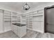 Large walk-in closet with custom shelving, drawers, and a modern chandelier at 2255 Buford Dam Rd, Buford, GA 30518