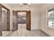 An open dining room with an elegant ceiling light, view of adjacent room, and gray wood floors at 2255 Buford Dam Rd, Buford, GA 30518