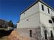 Side exterior of new home with gray siding and brick foundation at 2255 Buford Dam Rd, Buford, GA 30518