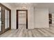 Open-concept foyer with a designer chandelier, view into other rooms, and gray wood flooring at 2255 Buford Dam Rd, Buford, GA 30518