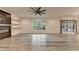 Open living room features modern ceiling fan, fireplace, floating shelves, and sliding glass doors at 2255 Buford Dam Rd, Buford, GA 30518