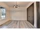A well-lit home office area featuring gray wood floors, a modern light fixture, and large window at 2255 Buford Dam Rd, Buford, GA 30518