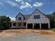 Under construction home featuring a two-car garage and inviting front porch area at 2257 Buford Dam Rd, Buford, GA 30518