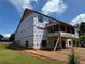 Rear view of under construction home featuring a deck, large windows and a partially finished basement at 2257 Buford Dam Rd, Buford, GA 30518