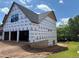 Side view of under construction home featuring a walkout basement and lush surroundings at 2257 Buford Dam Rd, Buford, GA 30518