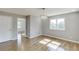 Sunlit living room with hardwood flooring, featuring a modern light fixture and neutral paint at 4840 Pisgah Rd, Cumming, GA 30028