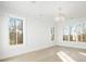 Bright bedroom features beautiful hardwood floors, large windows with scenic views, and a stylish modern ceiling light at 76 Telfair Ct, Acworth, GA 30101