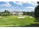 Beautiful view of a three-story clubhouse overlooking the green and sand traps on a golf course at 76 Telfair Ct, Acworth, GA 30101