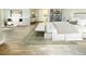 Spacious main bedroom with seating area and a bench in front of the bed with light hardwood floors at 76 Telfair Ct, Acworth, GA 30101
