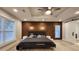 Stunning main bedroom features a wood accent wall, ceiling fan, and light gray wood flooring at 1089 White Oak Sw Ave, Atlanta, GA 30310