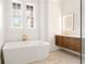 Modern bathroom with a standalone tub, wood vanity, and sleek fixtures under bright windows at 1585 S Ponce De Leon Ave # M4, Atlanta, GA 30307