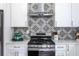Modern kitchen with stainless steel appliances and gray patterned backsplash at 1699 Olympian Sw Way, Atlanta, GA 30310