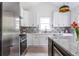 Modern kitchen with stainless steel appliances, granite island, and white shaker cabinets at 1699 Olympian Sw Way, Atlanta, GA 30310