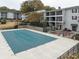 Winterized community pool with green cover surrounded by manicured landscaping and nearby condo buildings at 1150 Collier Nw Rd # H6, Atlanta, GA 30318